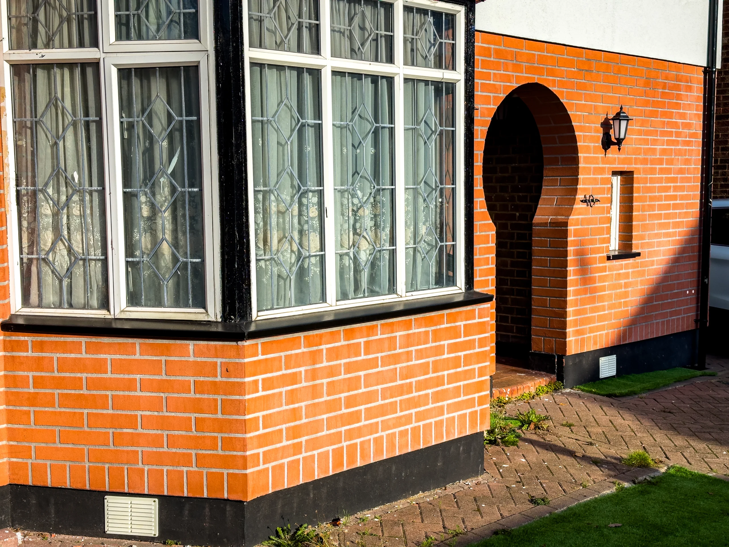 Close-up of a house exterior showing red brick walls