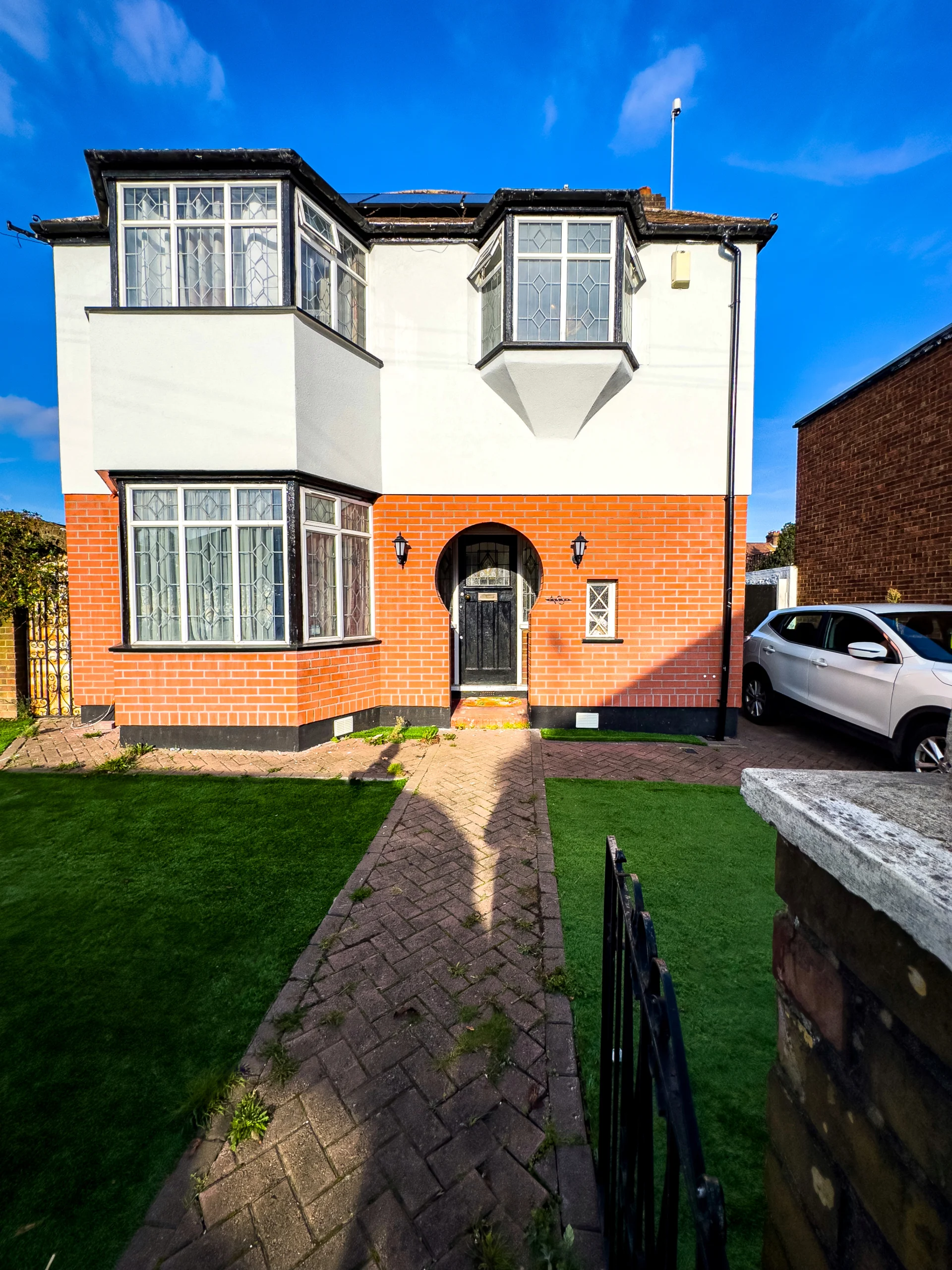 Front view of a two-storey house with red brick and white exterior walls