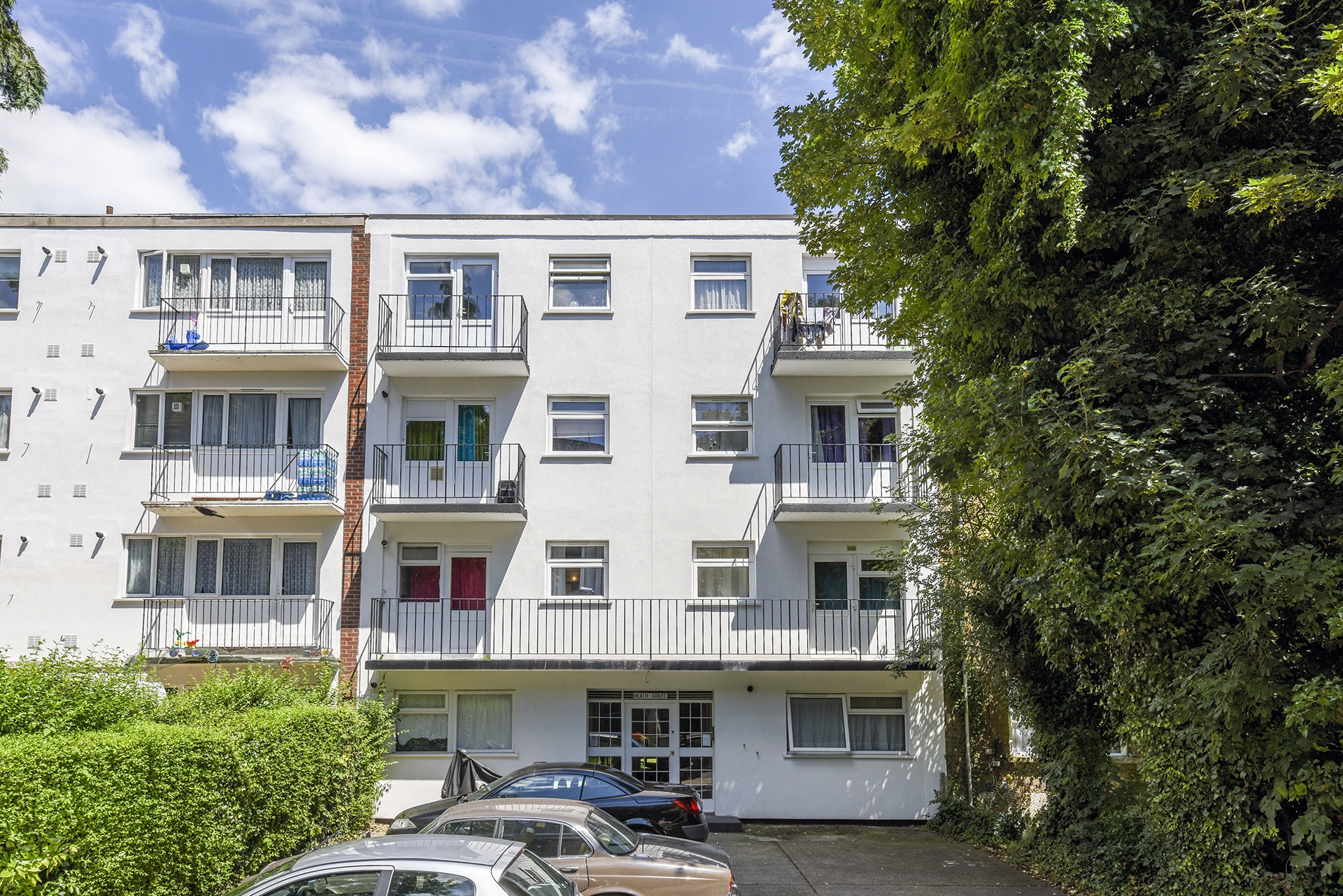 Refurbished residential block with new white external wall insulation and a cleaner, modern finish