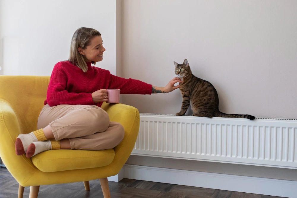 Woman relaxing and petting a cat enjoying the warmth after HIU installation