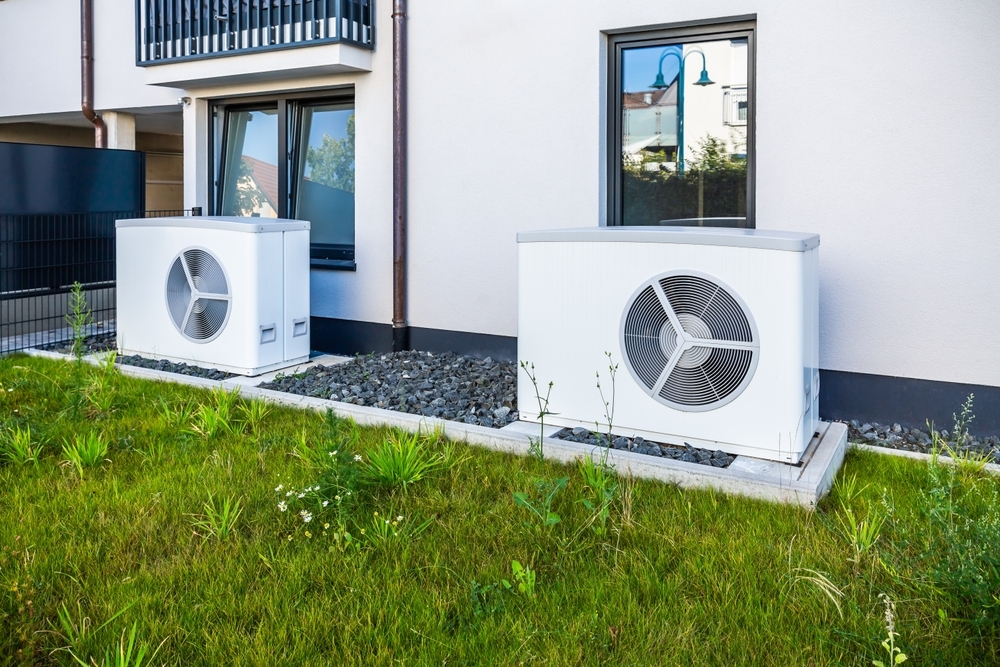 Two air source heat pumps installed outside of new and modern city house