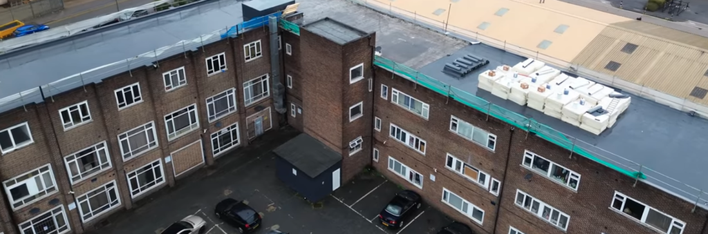 Aerial view of apartment block with completed flat roof replacement and safety edge protection