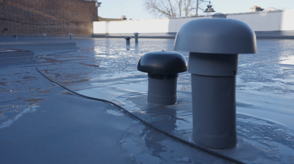 Close-up of flat roof ventilation outlets and waterproof membrane