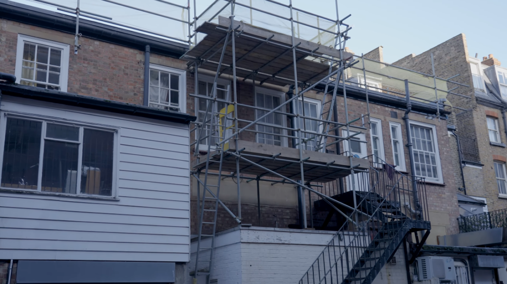 Rear view of commercial property with scaffolding for roof works